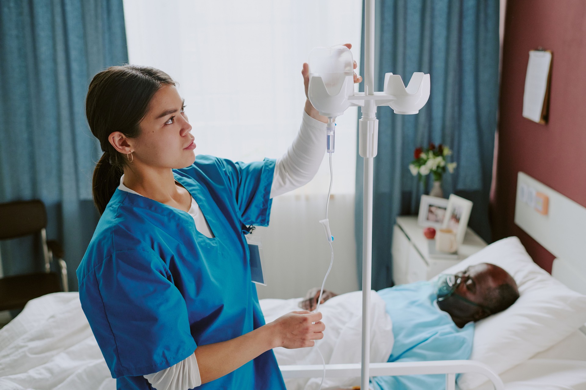 Nurse Attending Elderly Patient in Hospital Room